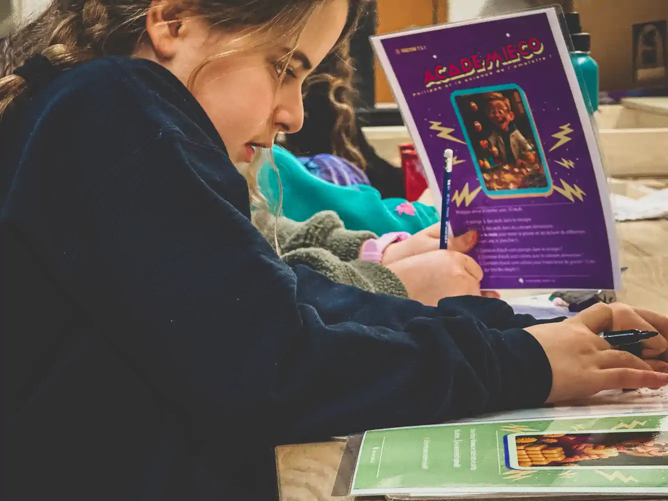 Un enfant fier montre ce qu'il vient de réussir pendant une activité de maths.